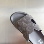 Grey Louis Vuitton slide sandal close-up with embossed monogram strap and open toe