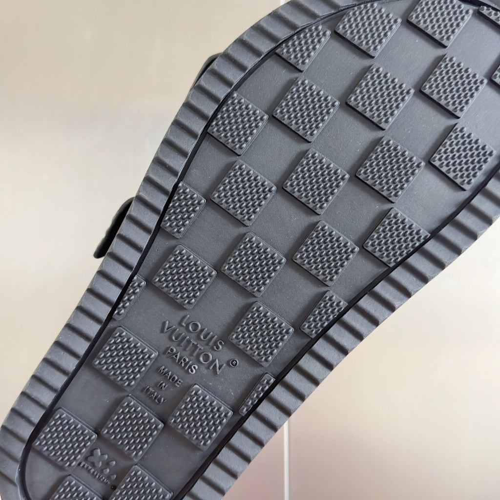 Black rubber outsole with textured tread and Louis Vuitton logo, featuring grip pattern.