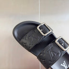 Black Louis Vuitton slide sandal close-up: embossed strap with silver-tone buckle and logo.