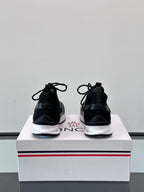 Black Moncler sneakers from back, showing heel tabs and white midsole edging.