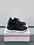 Black Moncler lace-up sneakers with chunky white midsole and sporty mesh upper.