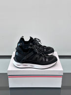 Black Moncler lace-up sneakers with chunky white midsole and sporty mesh upper.