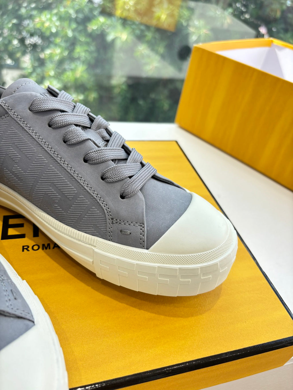 Fendi ladies lace-up sneakers close-up, gray textured upper with white rubber sole