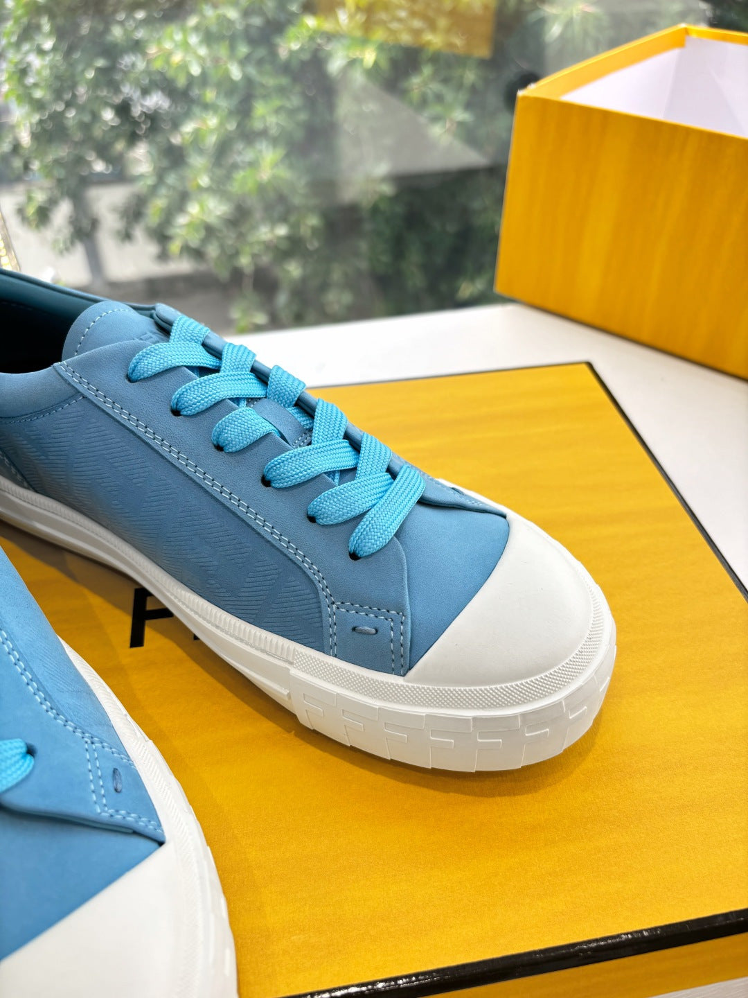 Fendi ladies low-top sneakers close-up, light blue suede with turquoise lace and white sole