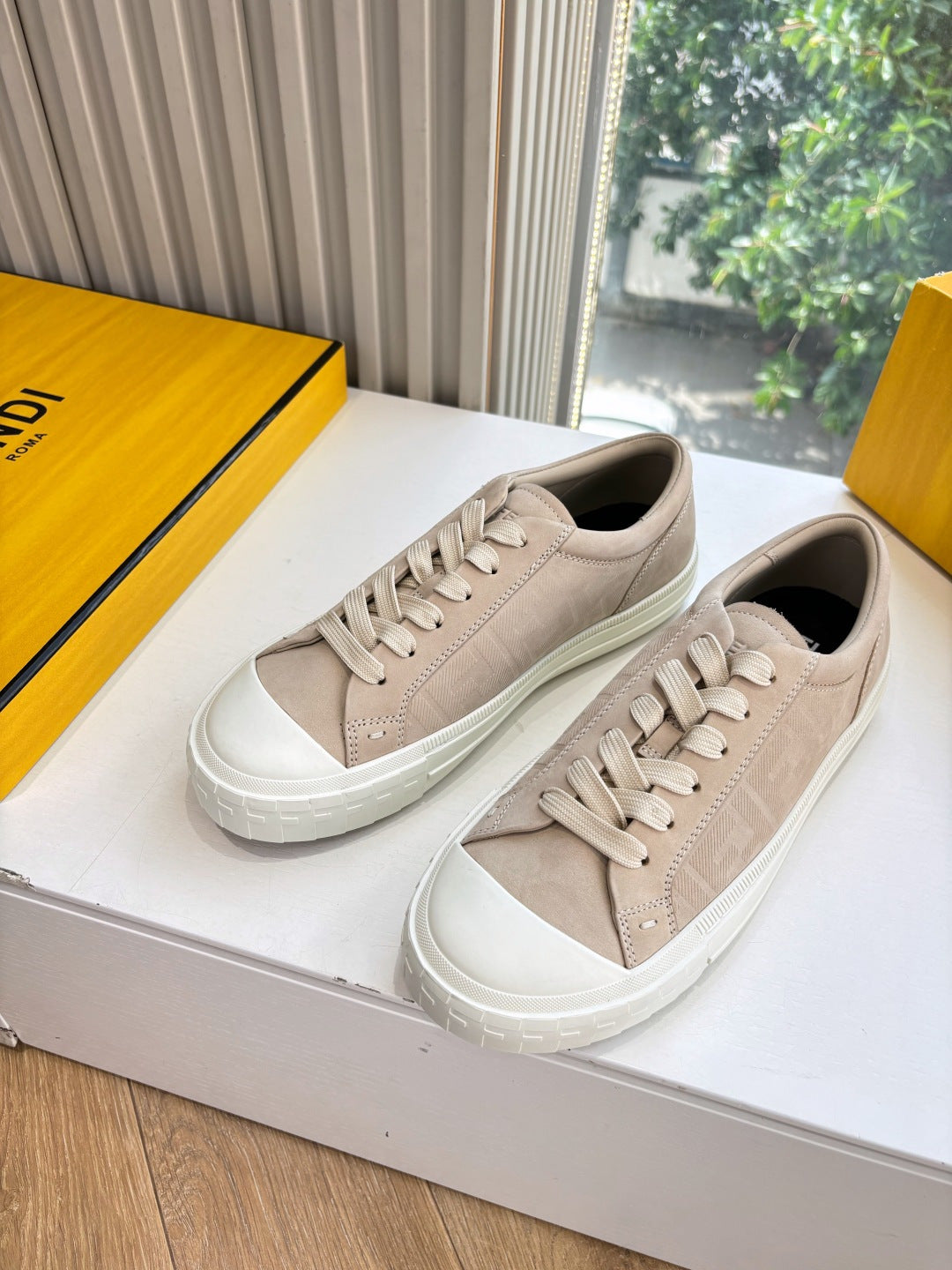Beige low-top sneakers with white rubber sole and lace-up closure, side view.
