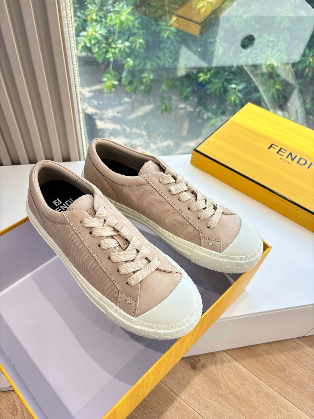 Beige low-top sneakers with white rubber sole and FENDI logo, lace-up.