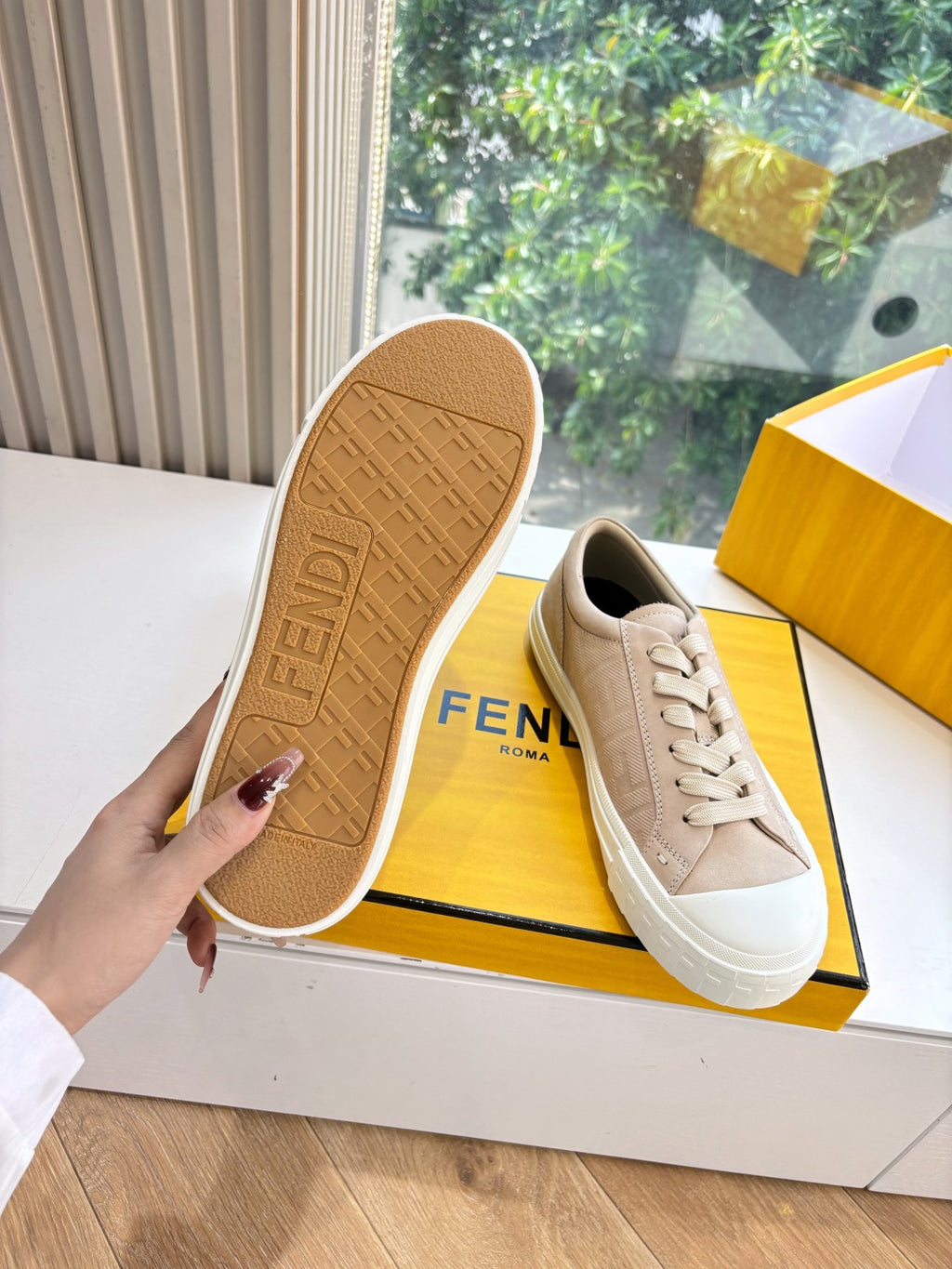 Beige sneaker outsole with FENDI text and tread pattern, viewed from bottom.