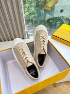 Beige low-top sneakers with lace-up closure, shown on display with shoe box.