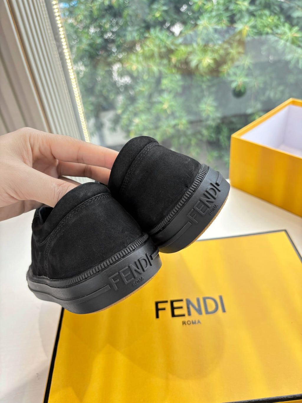 Black Fendi sneakers heel view with embossed logo on side and rubber sole