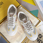 White low-top unisex sneakers with yellow, brown, and pink logo patches