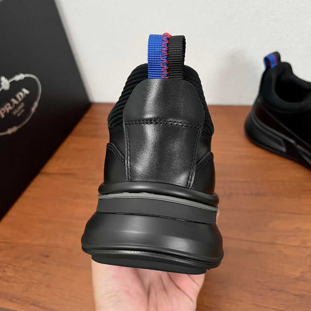 Black Prada unisex sneakers, heel view with blue-red pull tab and cushioned collar