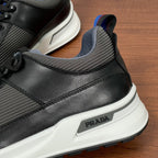 Prada sneakers side detail, PRADA logo plaque on black and gray upper with white sole