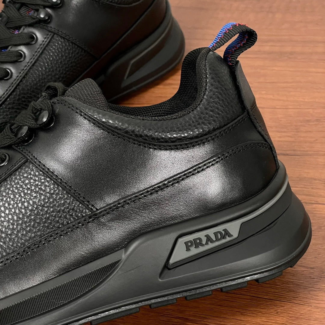 Prada unisex sneaker side close-up, black leather with PRADA logo badge