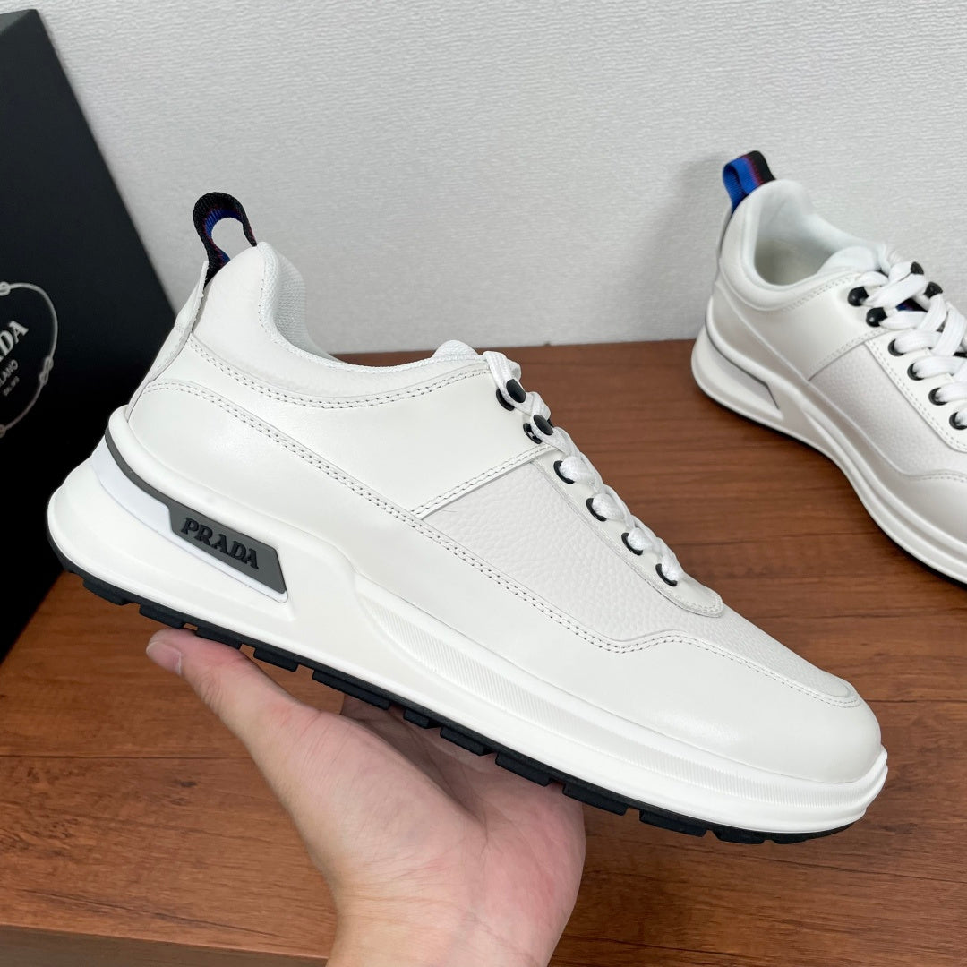 Prada unisex sneaker side view, white leather with PRADA logo and blue-red heel tab