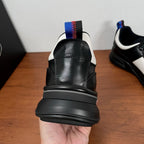 Prada unisex sneaker heel view, black leather with blue-red pull tab and cushioned sole