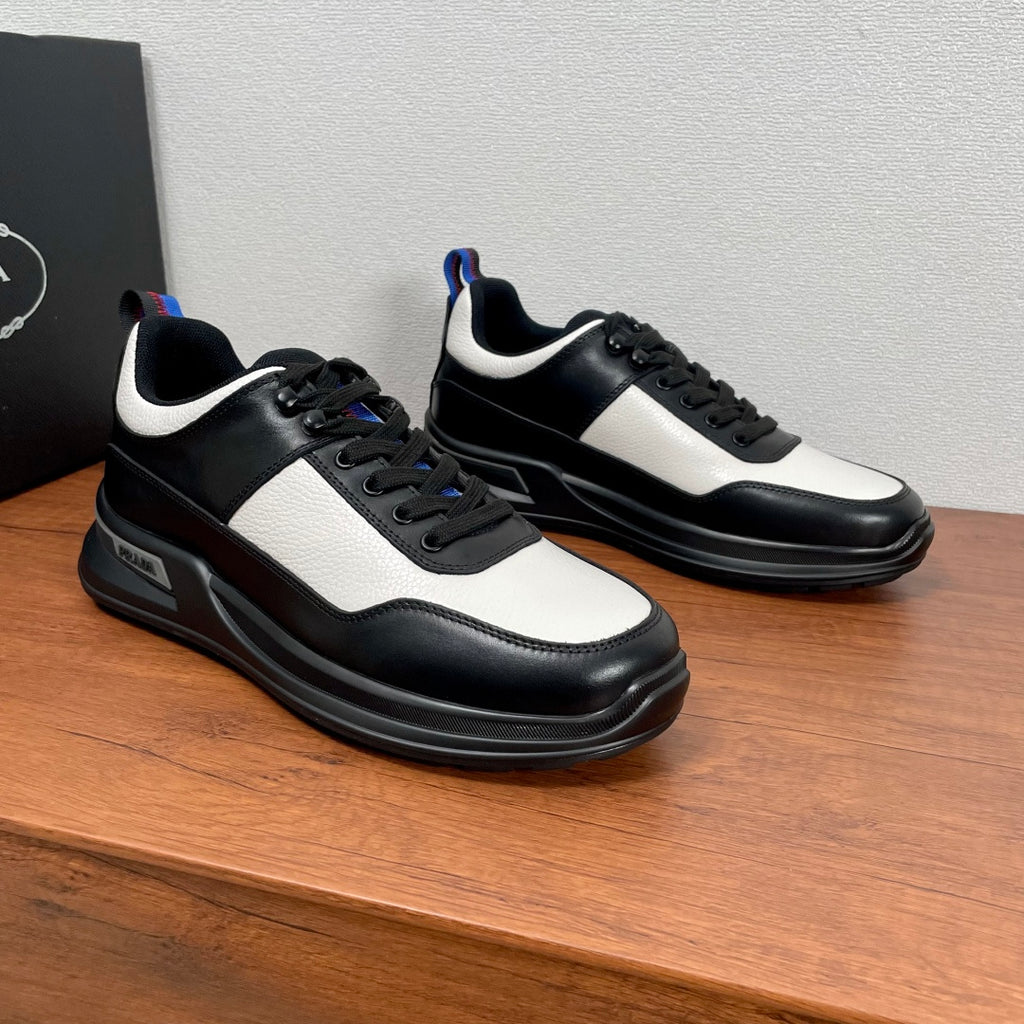 Prada unisex sneakers in black with white quarter panels and navy-red heel accents