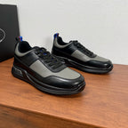 Prada unisex sneakers shown side view, black and gray leather with chunky sole