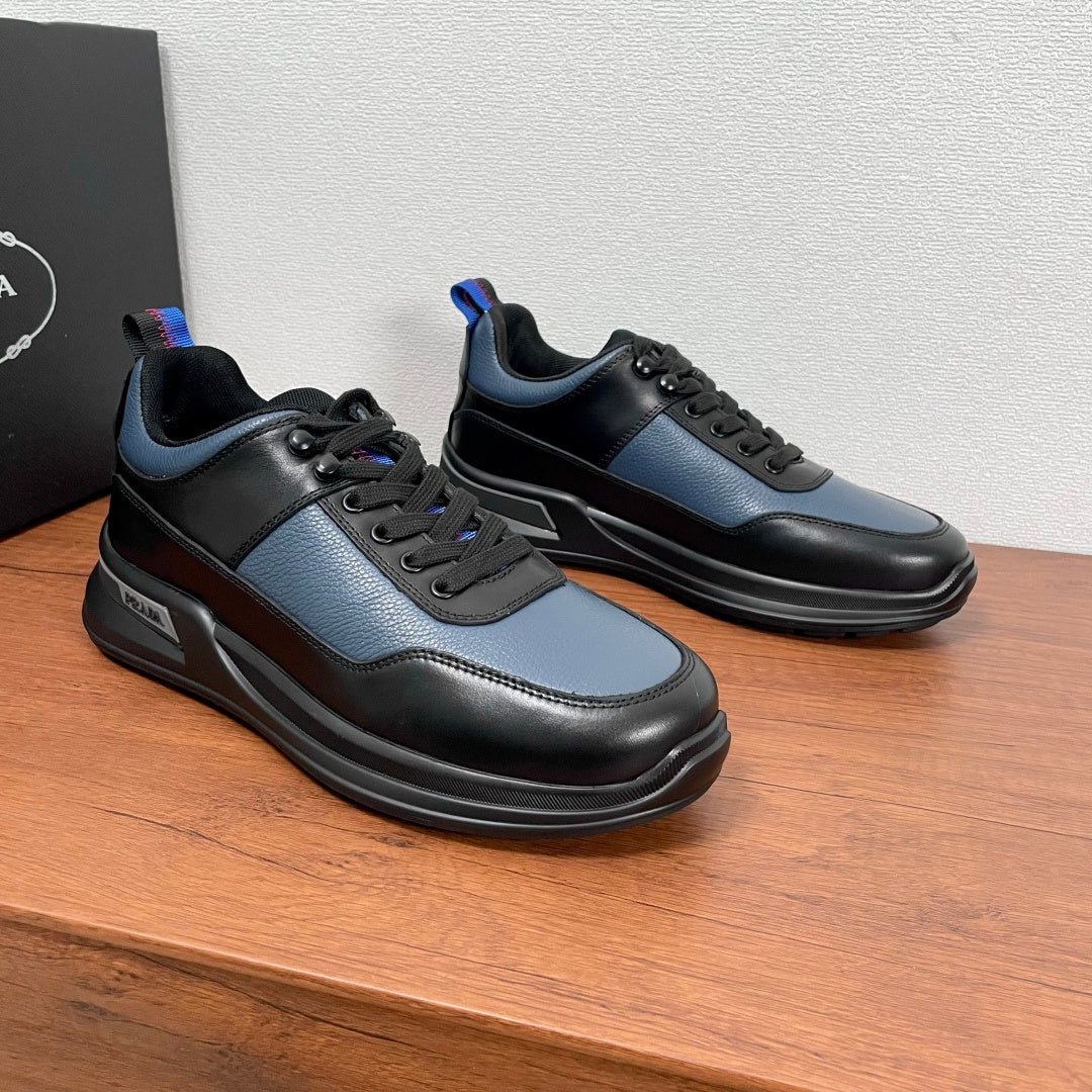 Prada unisex sneakers pair with black soles and black/blue panels, lace-up