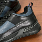 Prada unisex sneaker side detail with PRADA plaque, black and blue leather