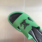 Louis Vuitton mint green sandal close-up with black footbed and logo detail on strap