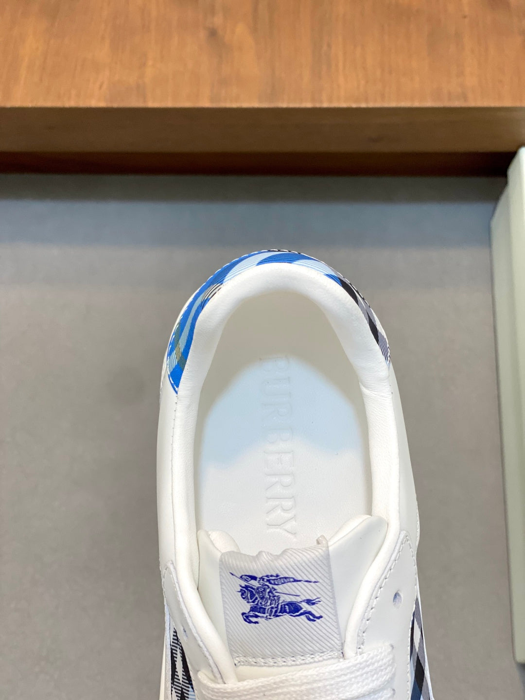 Sneaker interior showing Burberry logo print and blue check overlay