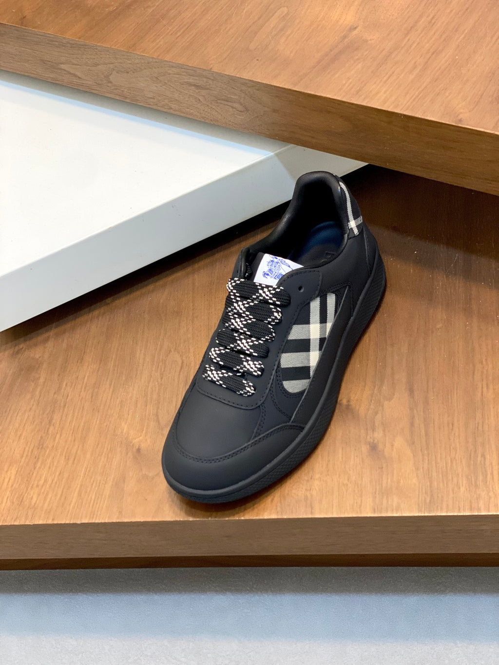 Burberry low-top sneaker, dark upper with check side panel and blue outsole edge