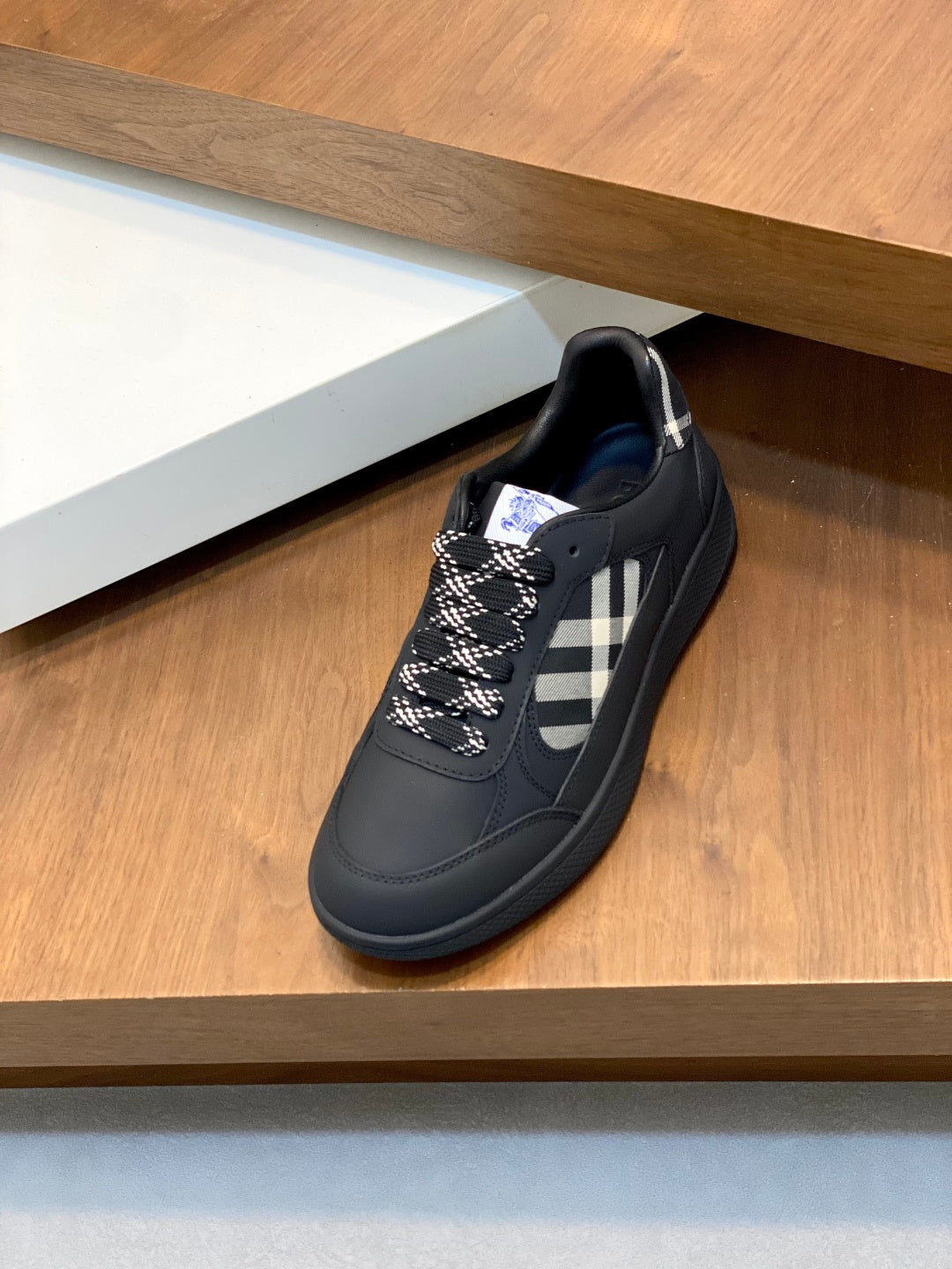 Burberry low-top sneaker, dark upper with check side panel and blue outsole edge