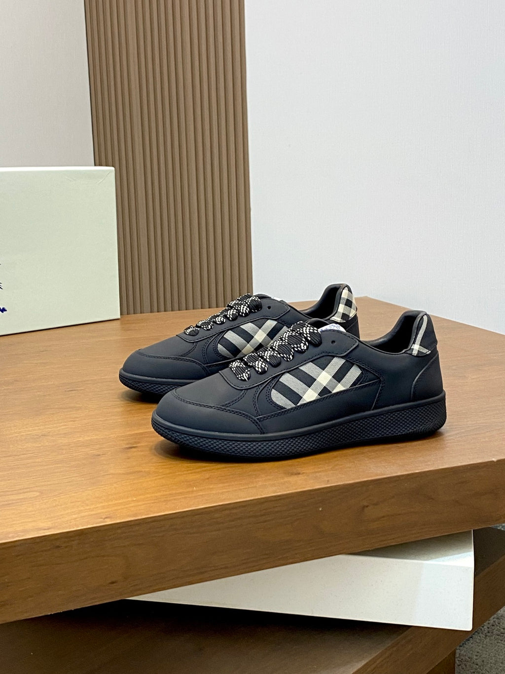 Burberry low-top sneakers pair, dark style with check strap and textured blue sole
