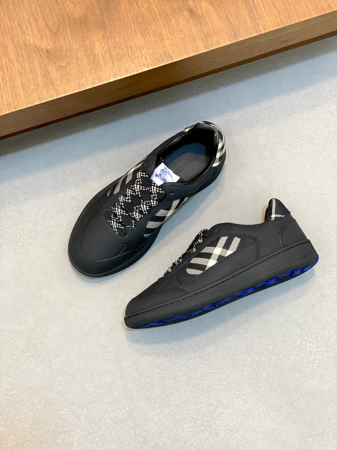 Burberry low-top sneakers, dark pair with check panel and blue trim at sole