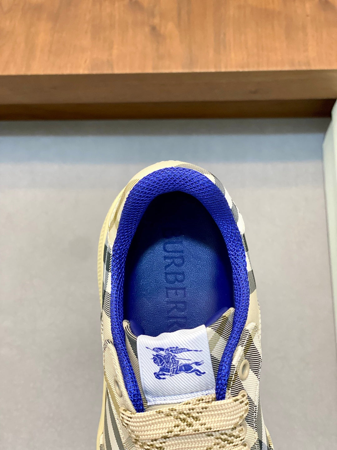 Burberry check sneaker tongue detail with blue lining and plaid fabric.