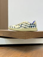 Burberry check low-top sneakers, beige plaid upper with blue trim and lace-up.