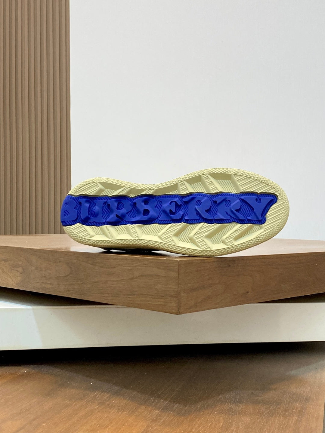 Burberry check sneaker outsole, beige sole with blue edge trim and tread.
