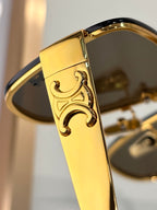 Celine sunglasses close-up of gold temple with embossed logo on tinted lens frame