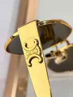 Celine sunglasses close-up: ornate gold temple detail and dark tinted lens