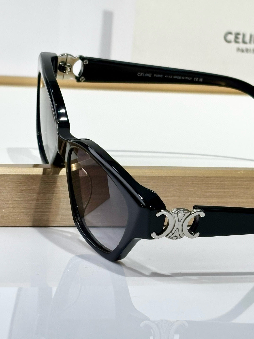 Black square eyeglasses with dark tinted lenses and gold C emblem on side