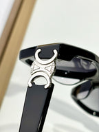 Close-up of black eyeglasses temple with silver C emblem and hinge detail