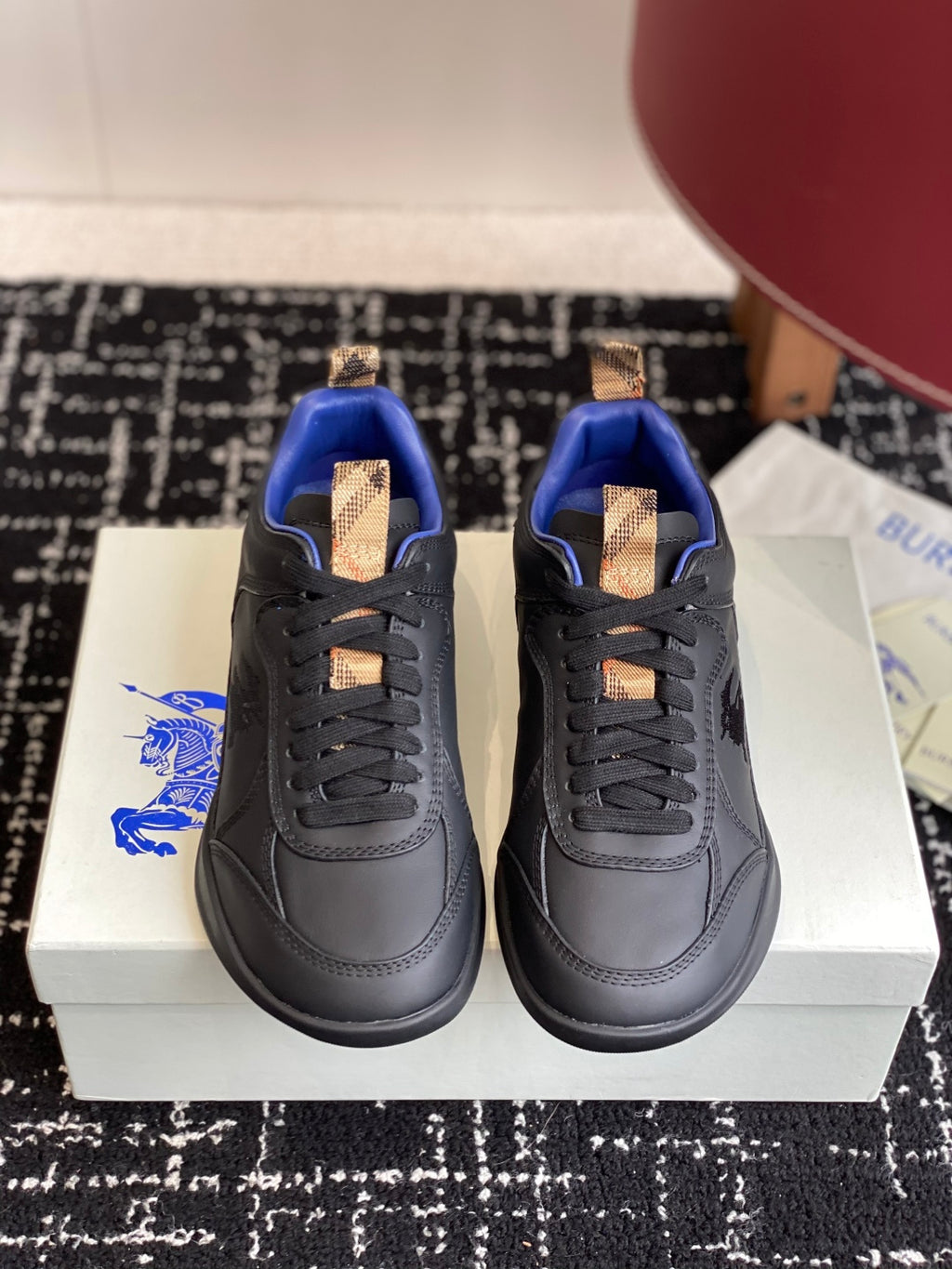 Black low-top sneakers with blue interior, tan lace-tab accents and rubber sole