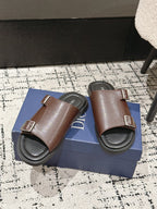 Dior brown leather slide sandals pair on box, showing double buckles