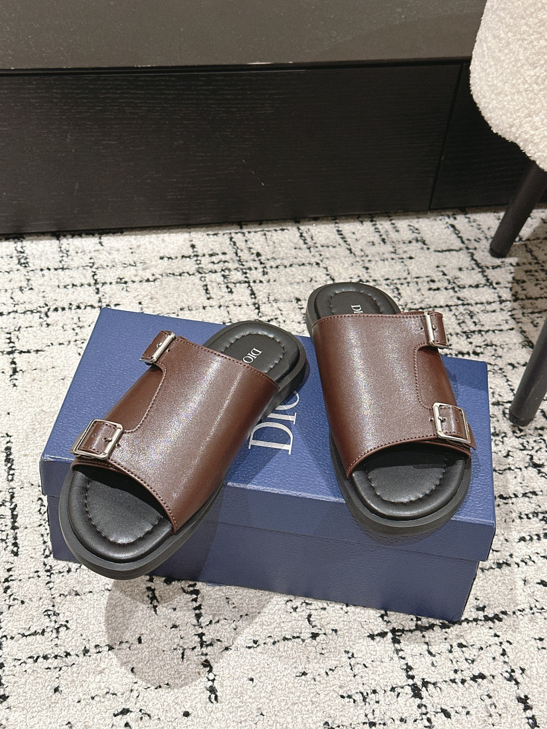 Dior brown leather slide sandals pair on box, showing double buckles