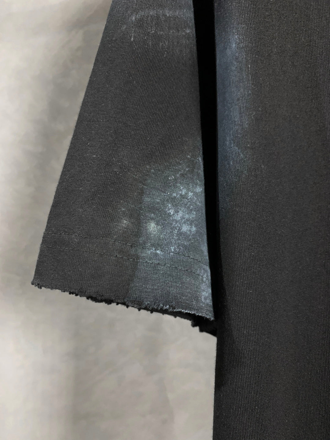 Balenciaga dark T-shirt hem and side seam detail with textured finish