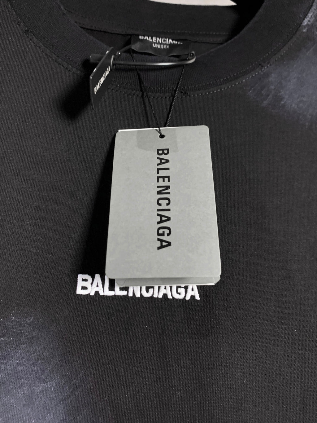 Balenciaga dark T-shirt neckline with brand tag and fabric texture detail