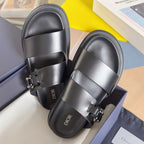 Black Dior slide sandals with wide strap and gold-tone buckle, rounded toe