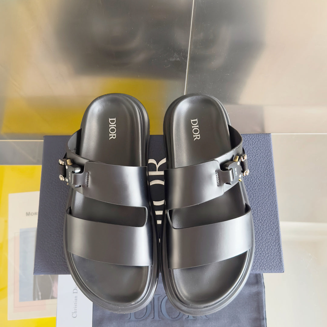 Black Dior slide sandals with wide straps and gold buckles, front view