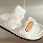 White monogram slide sandal with tan leather logo patch on front strap