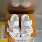 Front view pair of white monogram slide sandals with tan leather logo patch