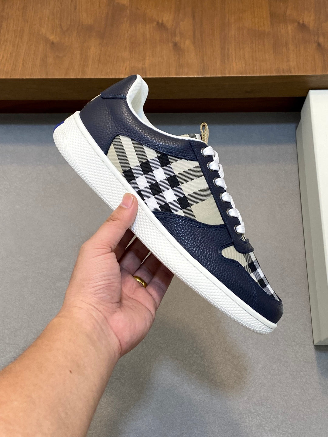 Navy low-top sneaker with check-pattern panel, white laces, and textured rubber sole