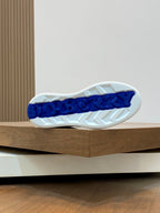 Outsole view of low-top sneakers with blue logo print and textured tread
