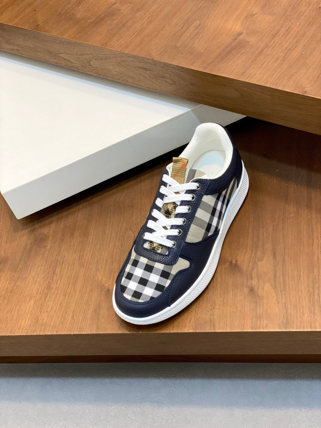 Navy lace-up sneakers with check-pattern side panels and white rubber sole