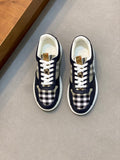 Navy low-top sneakers with white laces and black-and-white check panels