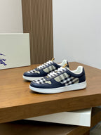 Pair of navy low-top sneakers with white laces and check-pattern uppers